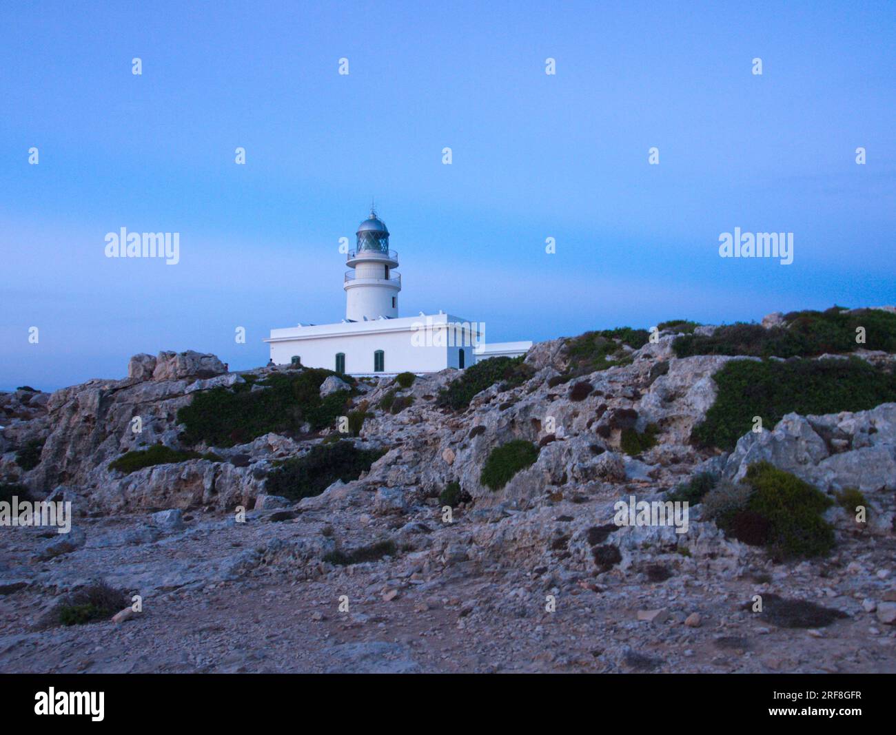 A lighthouse on the Island of Menorca surrounded by stony ground.  Un faro de la Isla de Menorca  rodeado de un terreno pedregoso. Stock Photo