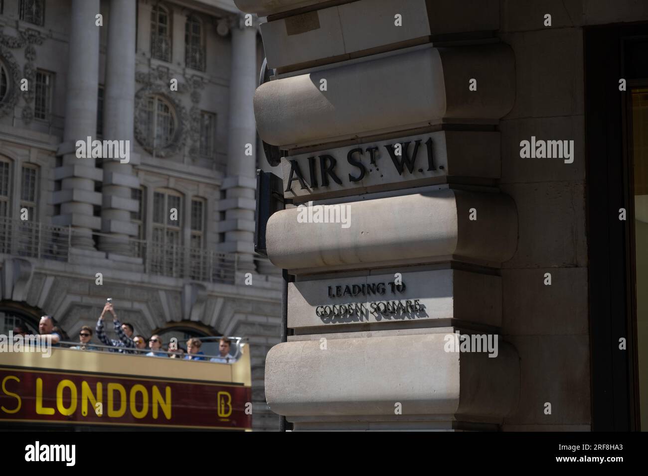 A London tour bus passing a sign saying Air Street, London, England, Stock Photo