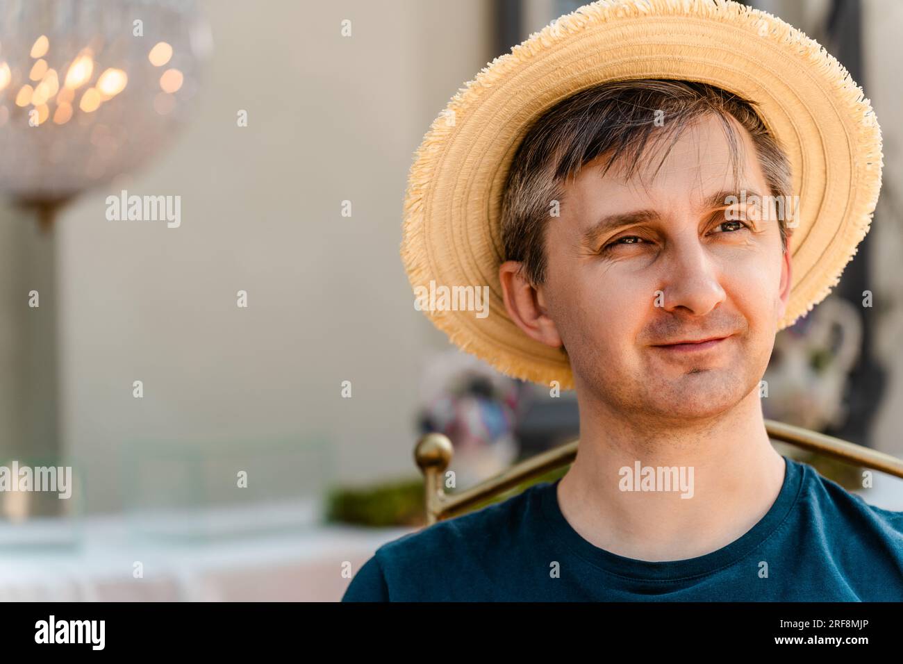 Close-up portrait of a smiling middle-aged man wearing a straw hat and T-shirt Stock Photo