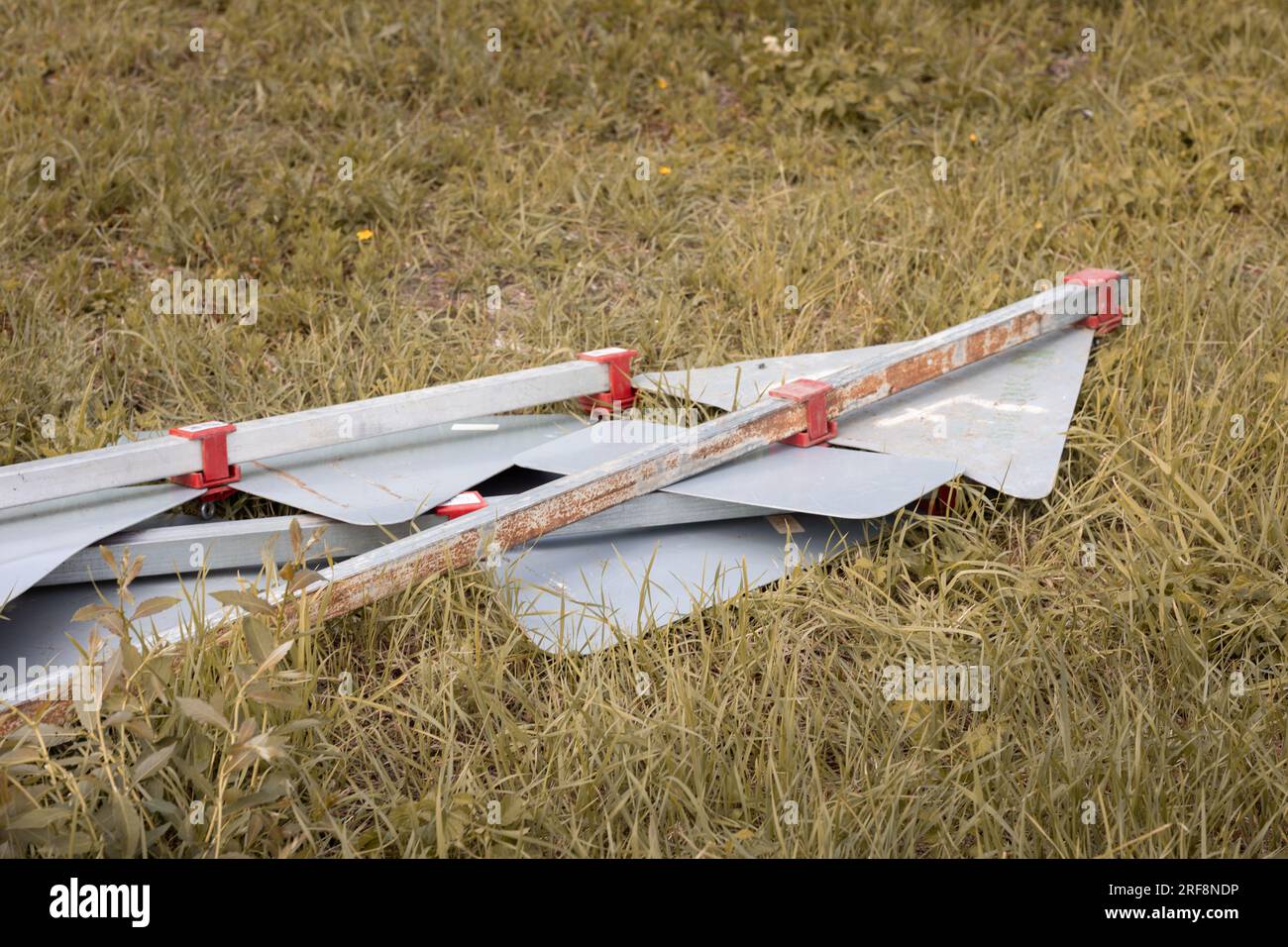 A bunch of road signs knocked over by the wind, laying face down on the
