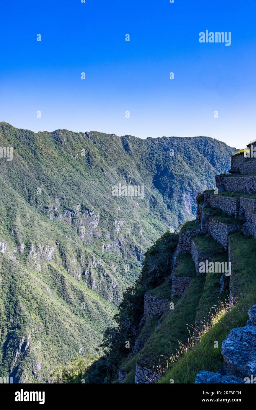 view of edge of Inca ruins of Machu Picchu towards the Urubamba river valley, Peru, South America Stock Photo