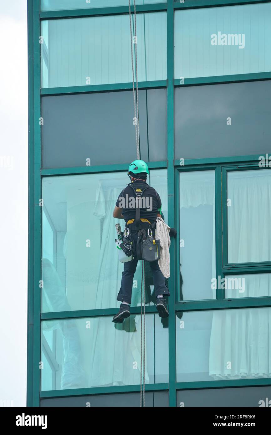 Industrial window cleaner man hanging on roofs with safety equipment