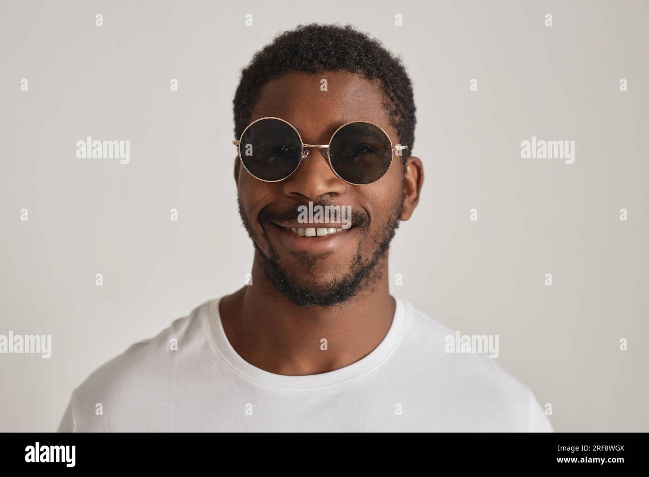 Minimal front view portrait black man wearing sunglasses against white background Stock Photo