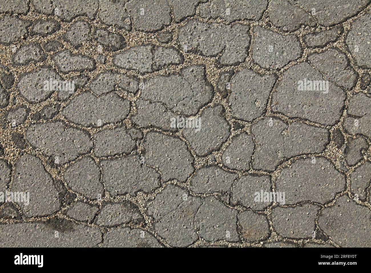 Asphalt surface of the road with a cracks in the middle, background