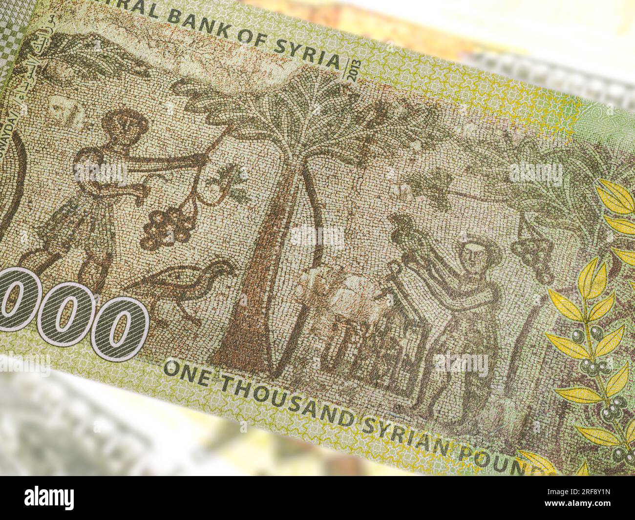 A close-up of a Syrian 1000 Pound banknote reveals intricate art and design. Amidst the country's turmoil, it showcases historical landmarks, symboliz Stock Photo