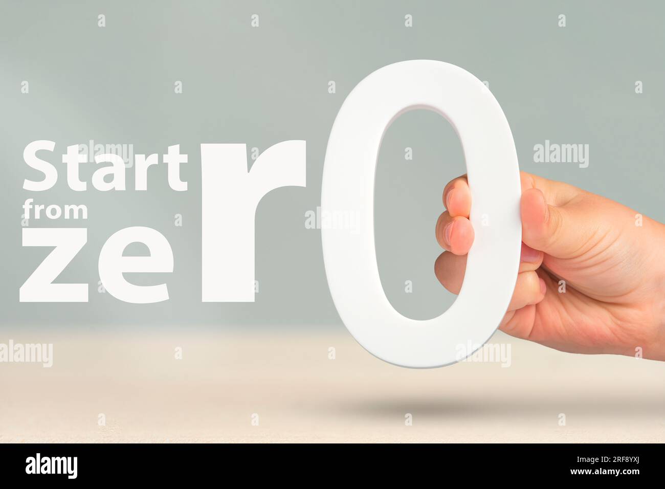 Start from zero close up concept photo of a hand holding a white zero
