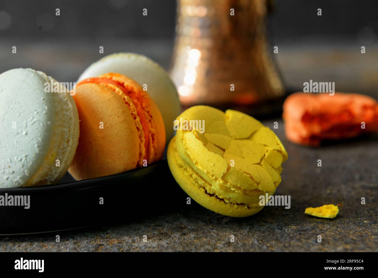 Plate with sweet macaroons on dark table Stock Photo