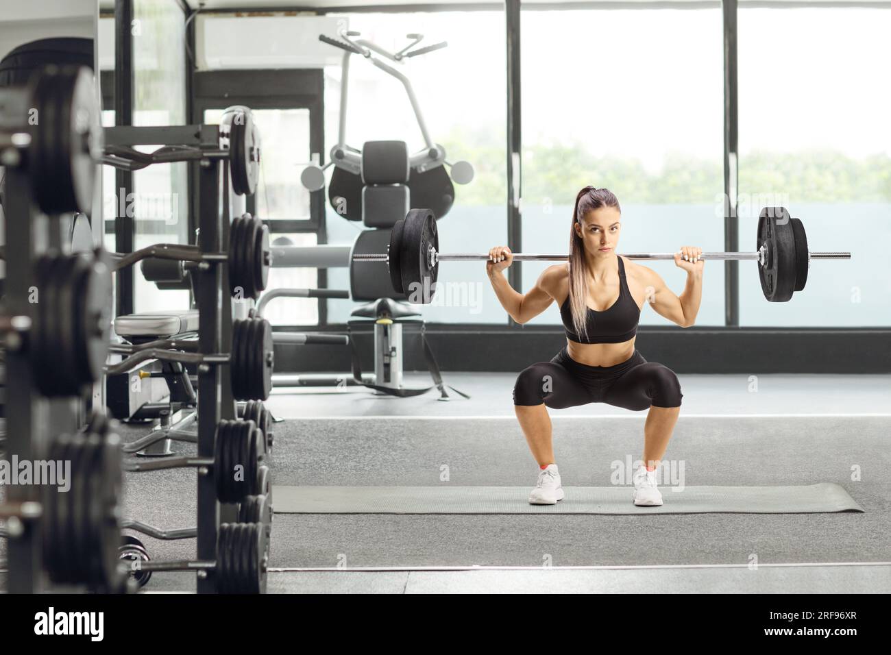 Full length portrait of a female bodybuilder lifting weights and