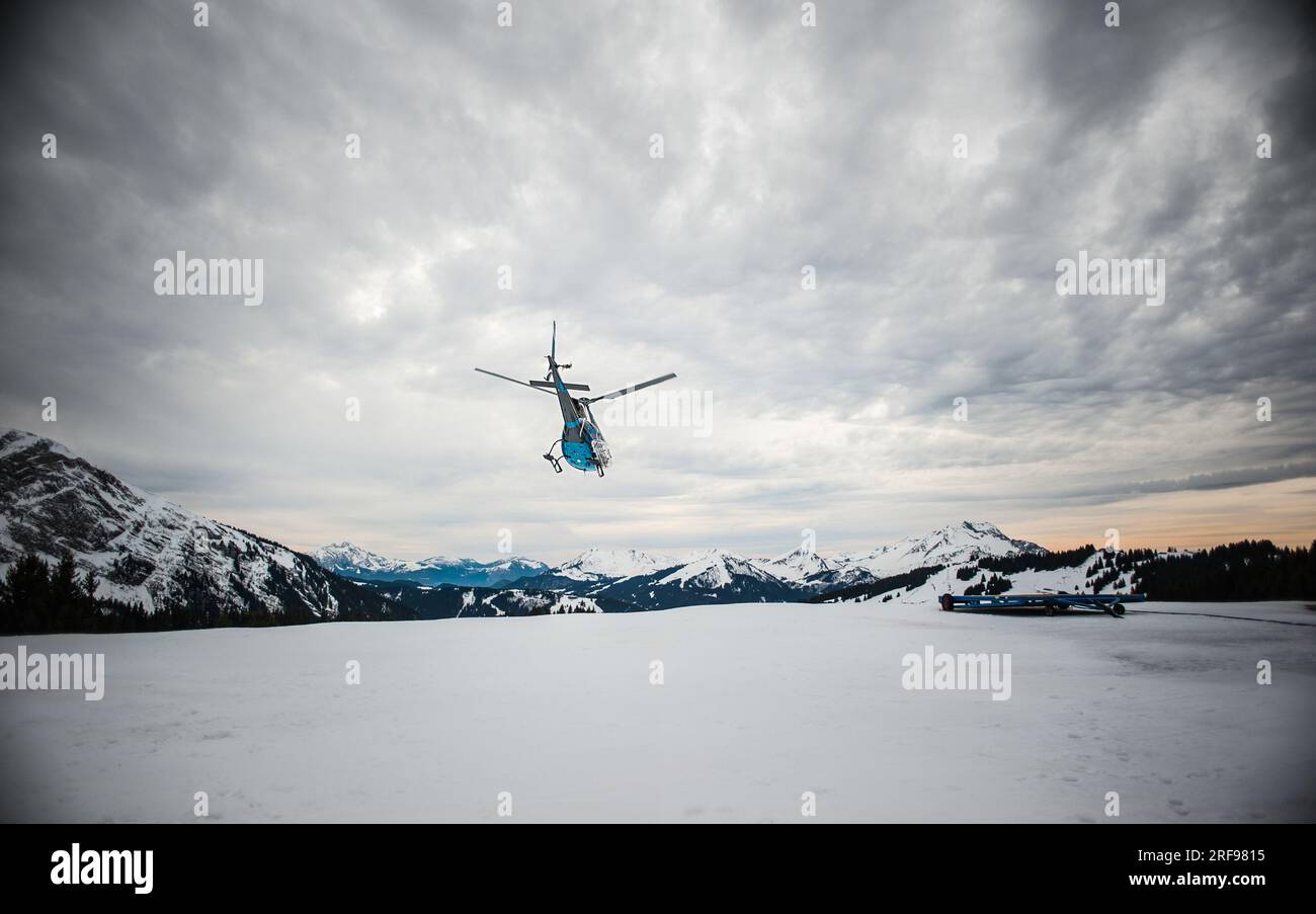 The trackers ensure the safety of the slopes for the skiers, a helicopter evacuates an injured person. Stock Photo