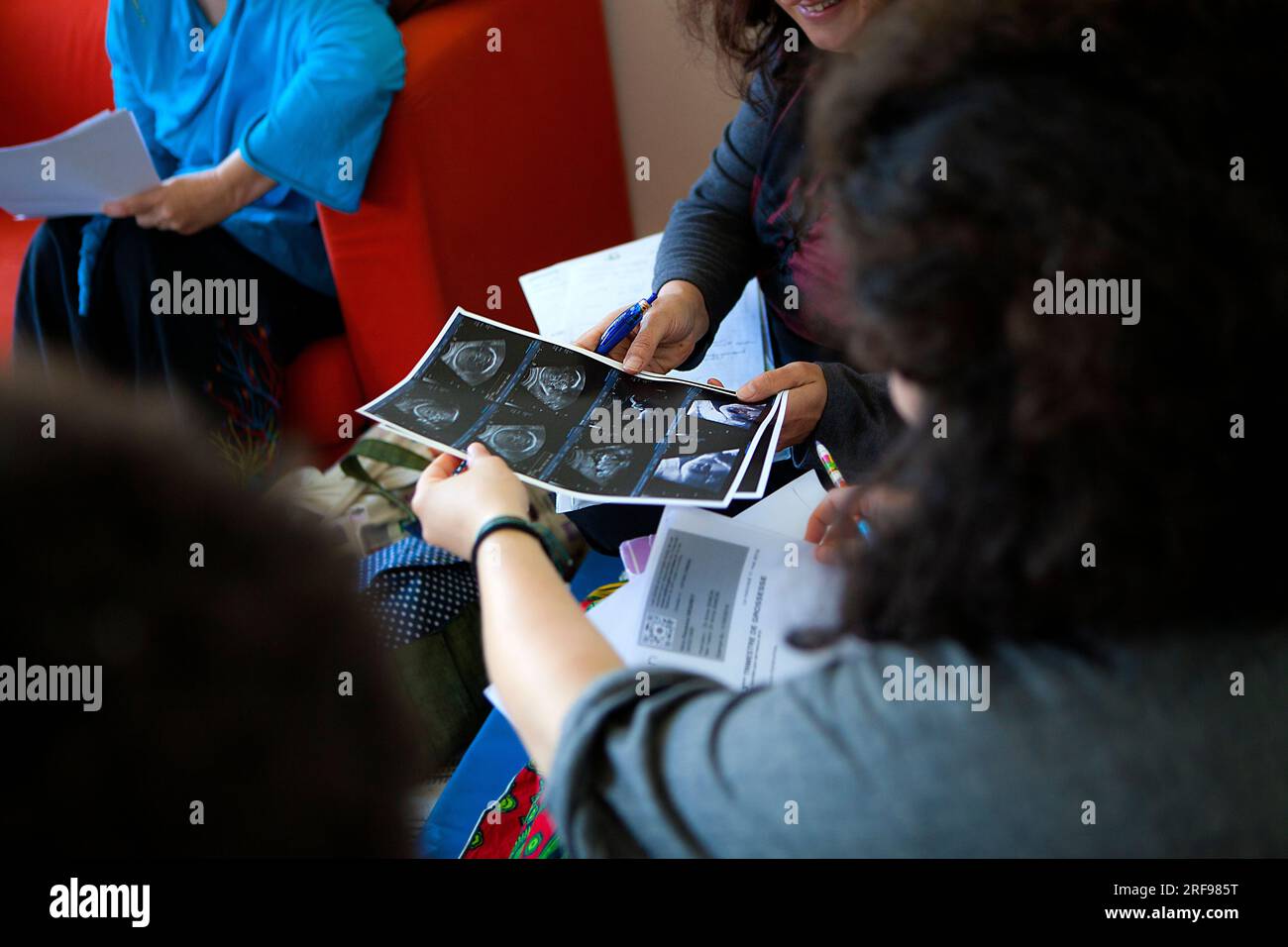 Liberal midwife accompanying a home birth, ultrasound of the fetus. Stock Photo