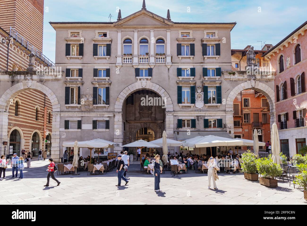 Verona street view with people in The Piazza Dei Signori; Verona Italy Europe. Spring sunshine in May. Stock Photo