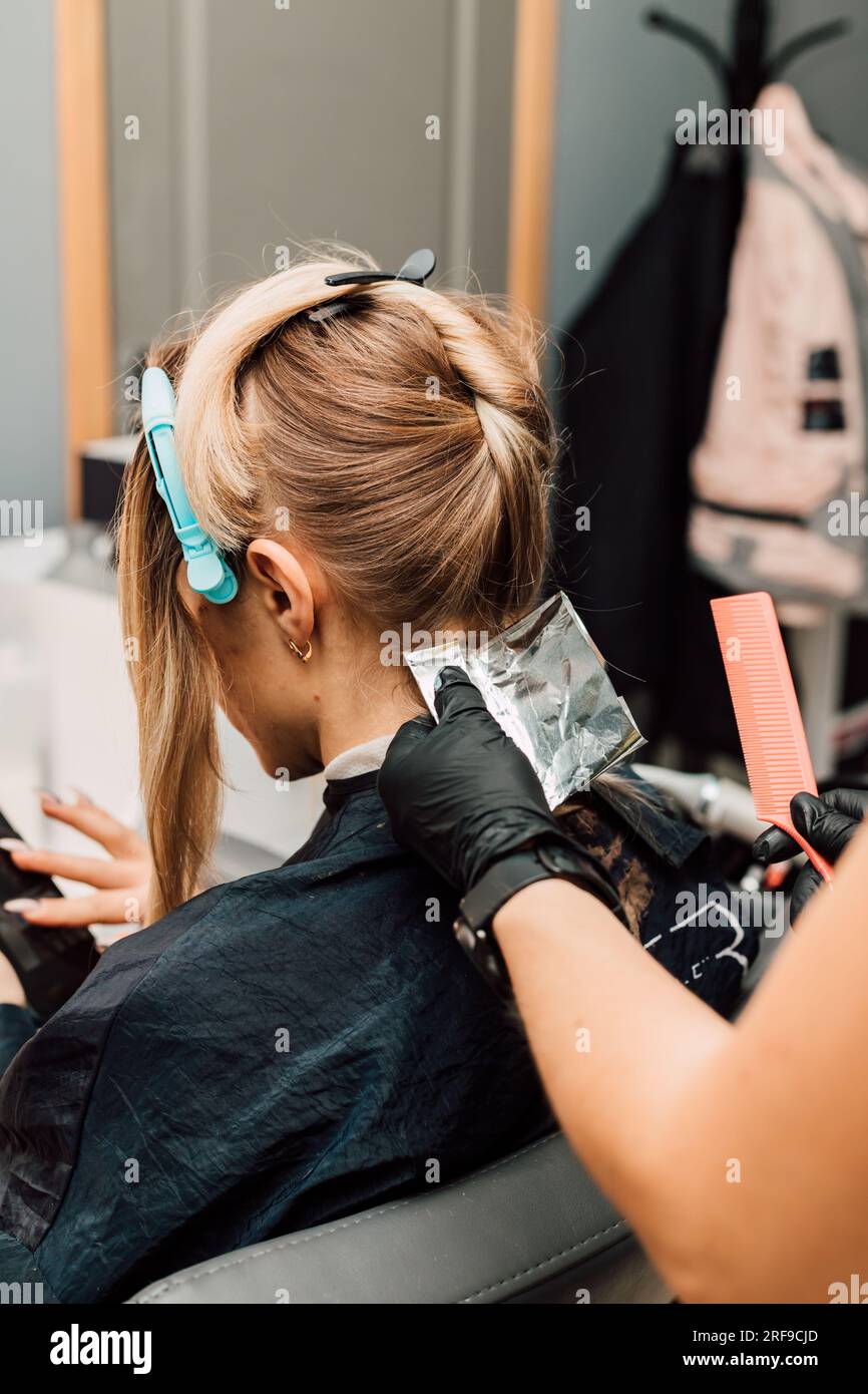 Hair coloring in white in a beauty salon. Process of applying dye to ...