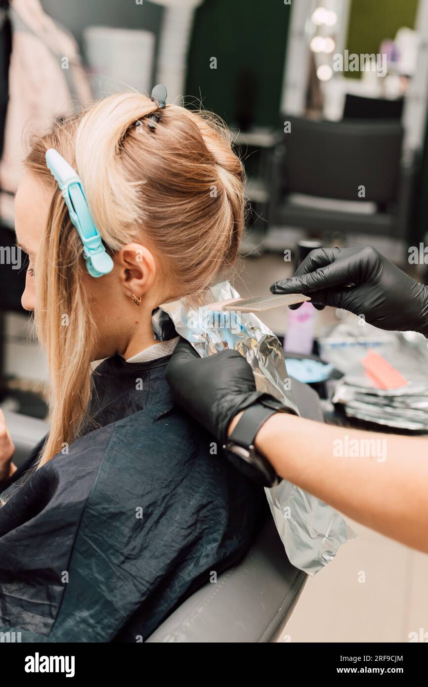 Hair coloring in white in a beauty salon. Process of applying dye to ...