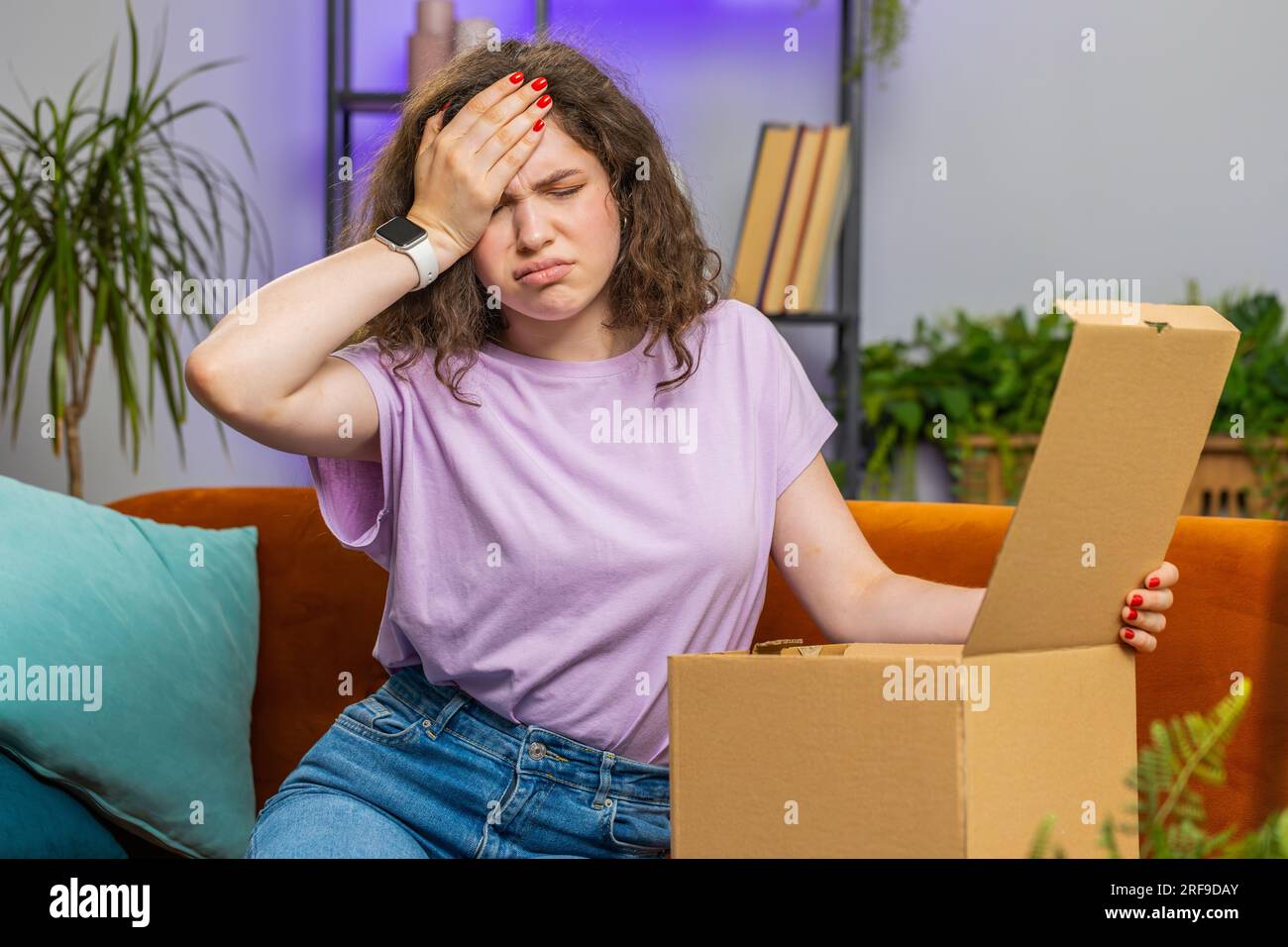Angry dissatisfied shopper young woman unpacking parcel feeling upset ...