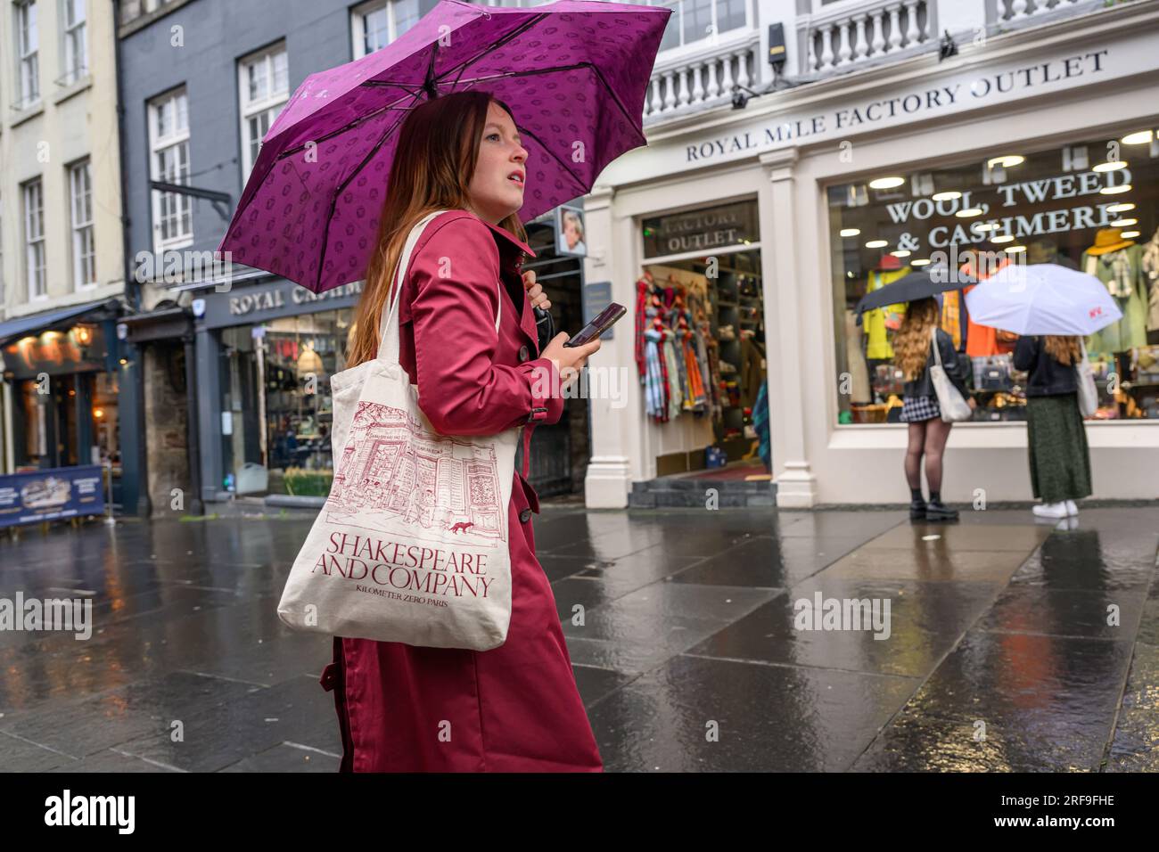 Shopper With Broken Umbrella & Mobile Phone On A Rainy Day On High Street, The Royal Mile, Edinburgh, Scotland, United Kingdom, UK Stock Photo