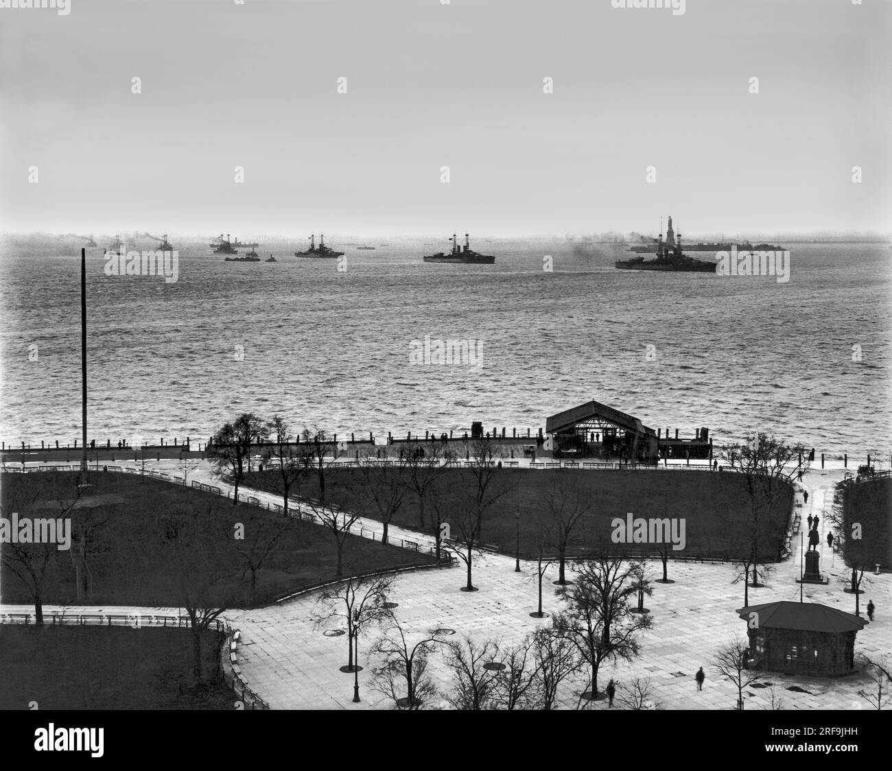 New York, New York:   November 24, 1916 The Navy fleet steaming up New York Bay past Battery Park at dusk so that the crews can root for Navy in the annual Army-Navy football game at the Polo grounds. The battleships arriving are the New York, Texas, Oklahoma, Connecticut, Florida, Utah, and Wyoming. Stock Photo