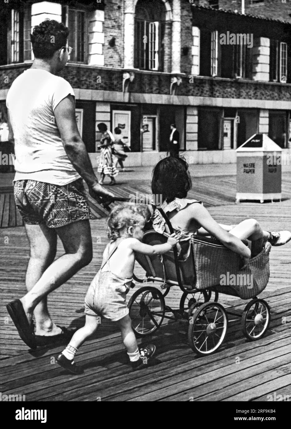 Brooklyn, New York, New York   August 28, 1948 The child takes over pushing the stroller when it becomes Mom's turn for a ride on a family outing at the Coney Island boardwalk. Stock Photo