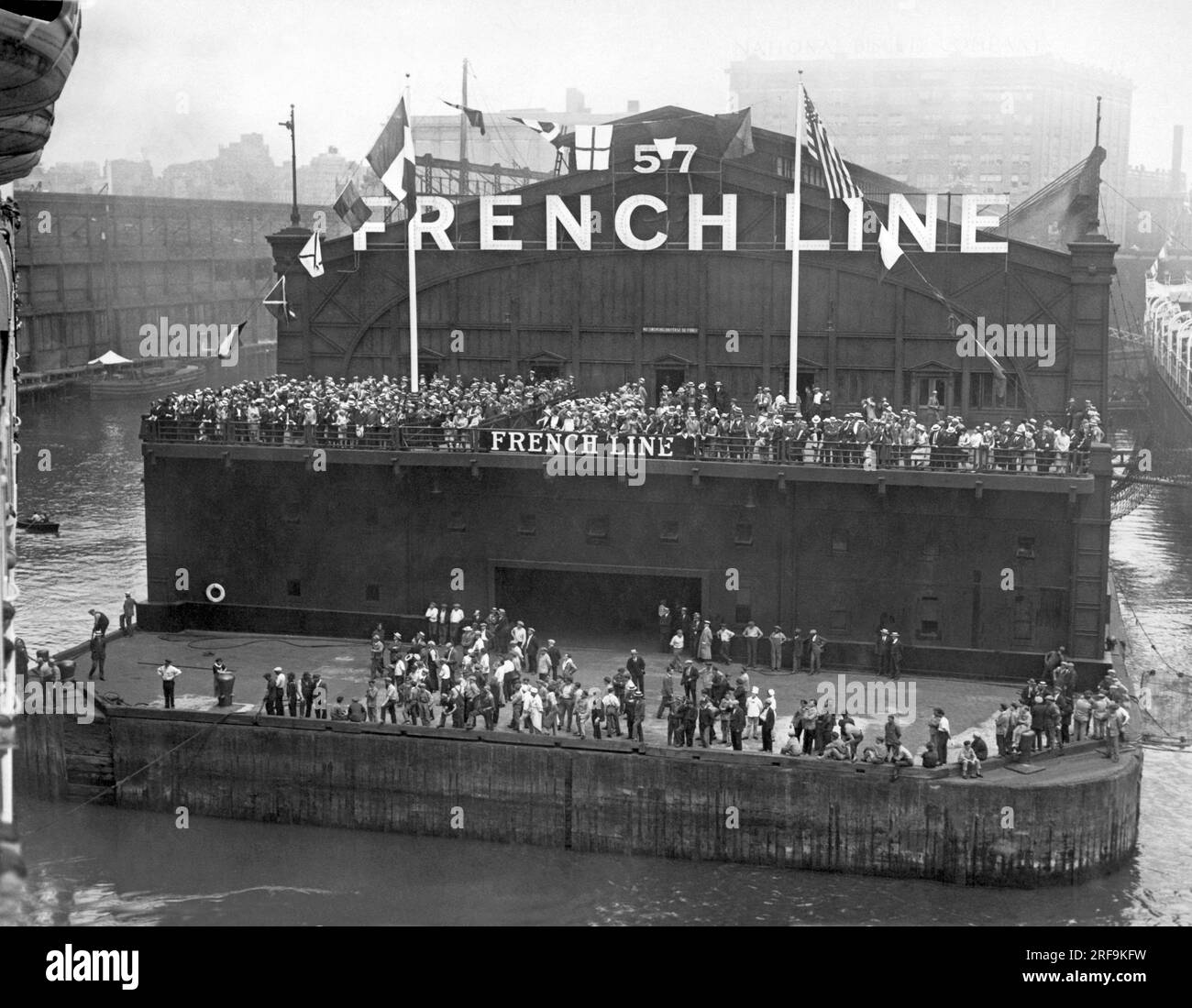 New York, New York:  June 28, 1927 Crowds at the pier of the French Line in New York City cheering the arrival of the new French Liner Ile de France upon completion of the first half of her maiden voyage. It is the largest passenger ship built after the war. Stock Photo