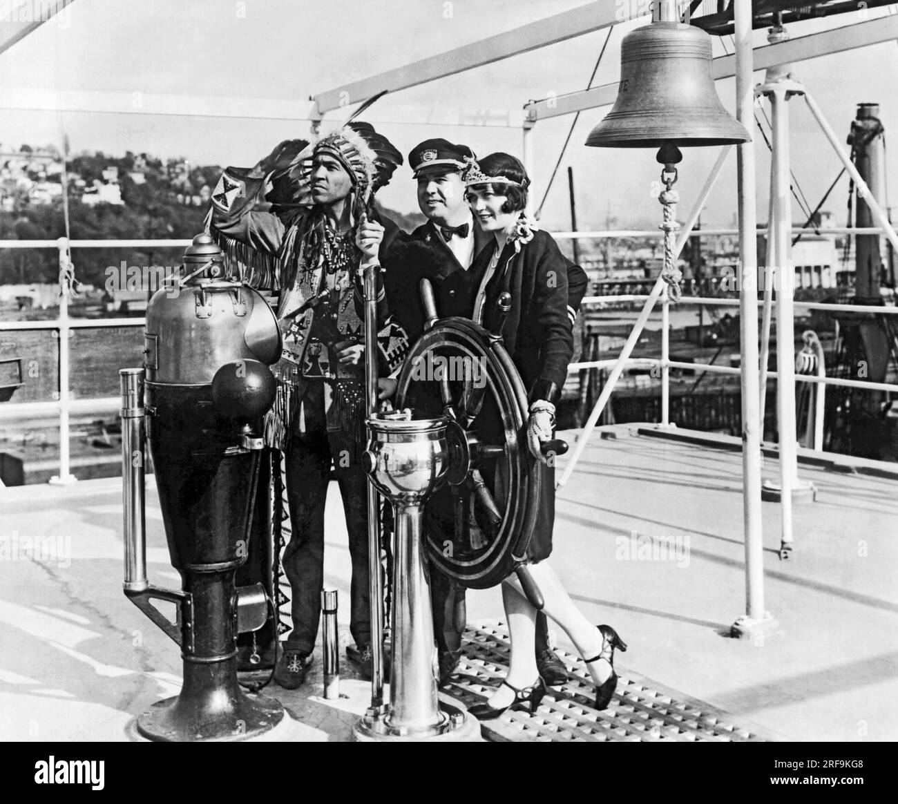 Seattle, Washington,  1928 J.B. Downing, Chief Officer of the American Mail Liner, 'President Grant', gives Chief Kiutus Tecumseh of the Yakima Tribe, and Miss Leona Wilson, Queen of the Apple Blossoms' Festival, their first lesson in navigation when they visited his ship in Seattle Harbor recently. Stock Photo