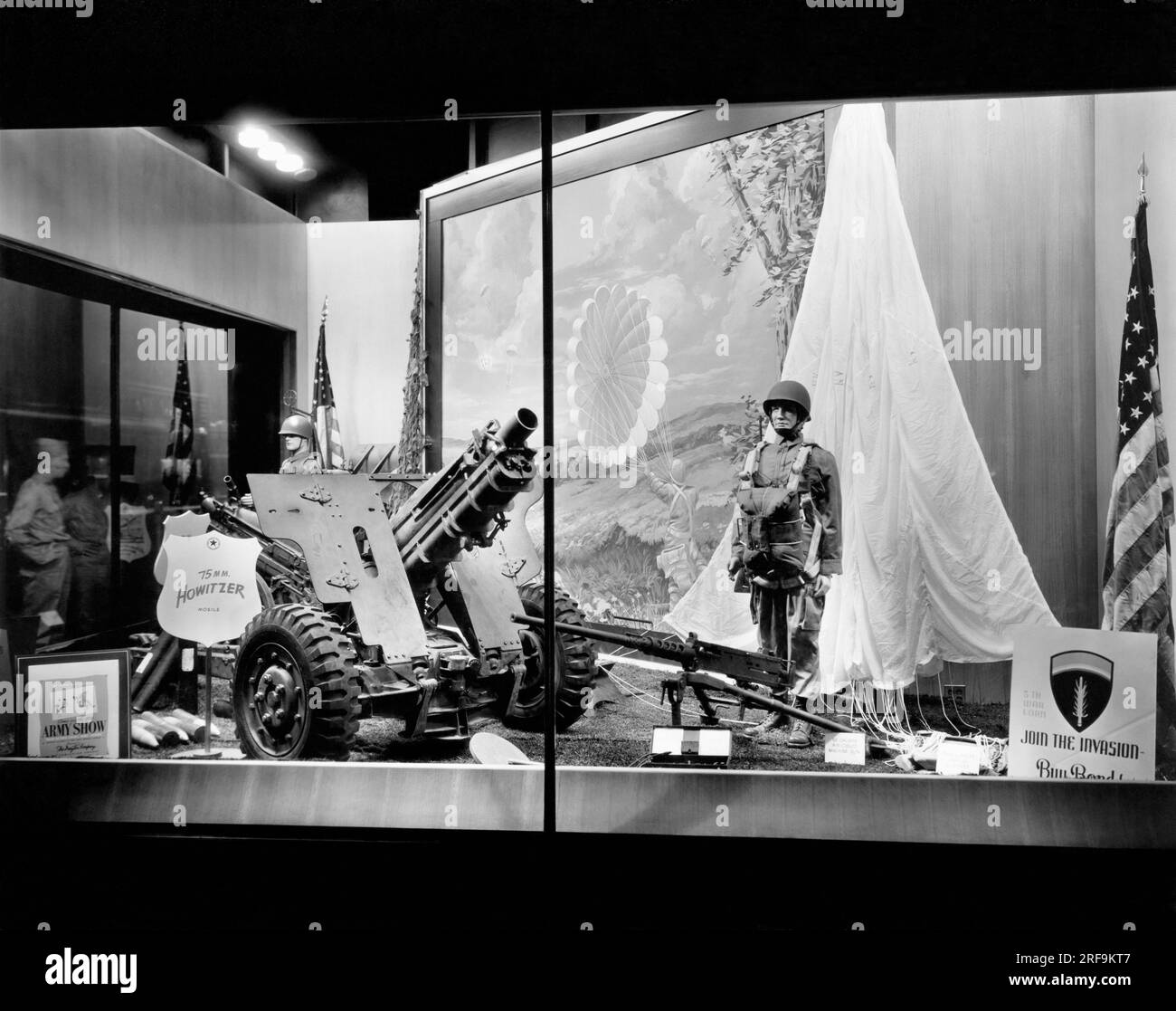 Minneapolis, Minnesota:   June 12, 1944. Less than a week after D-Day, President Roosevelt calls upon the country to purchase Treasury bonds as part of the 5th War Loan drive. The Dayton Company, a major department store, has a window display supporting the drive, and is also the sponser of  the Army Show featuring the 'This Is The Army, Mrs. Jones',  display of war material. Stock Photo