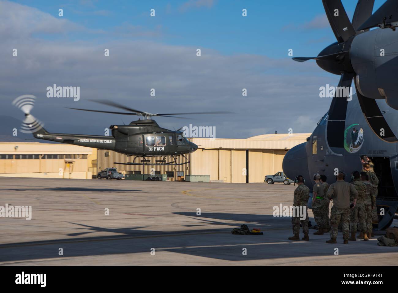 A Chilean helicopter flies in front of an AC-130J Ghostrider from the ...