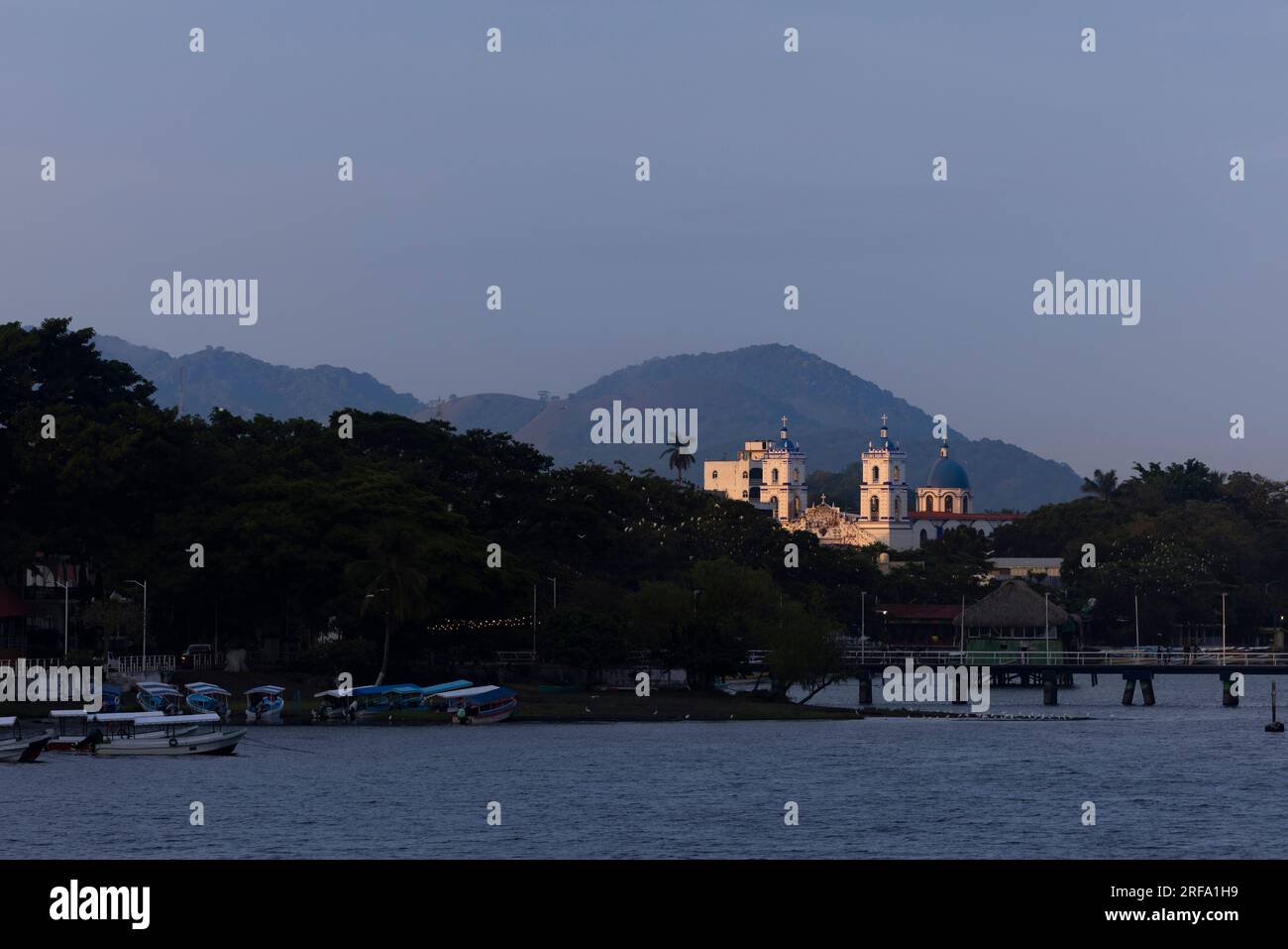 Sunset illuminates the historic urban core and mountains of Lake Catemaco, Veracruz, Mexico. Stock Photo