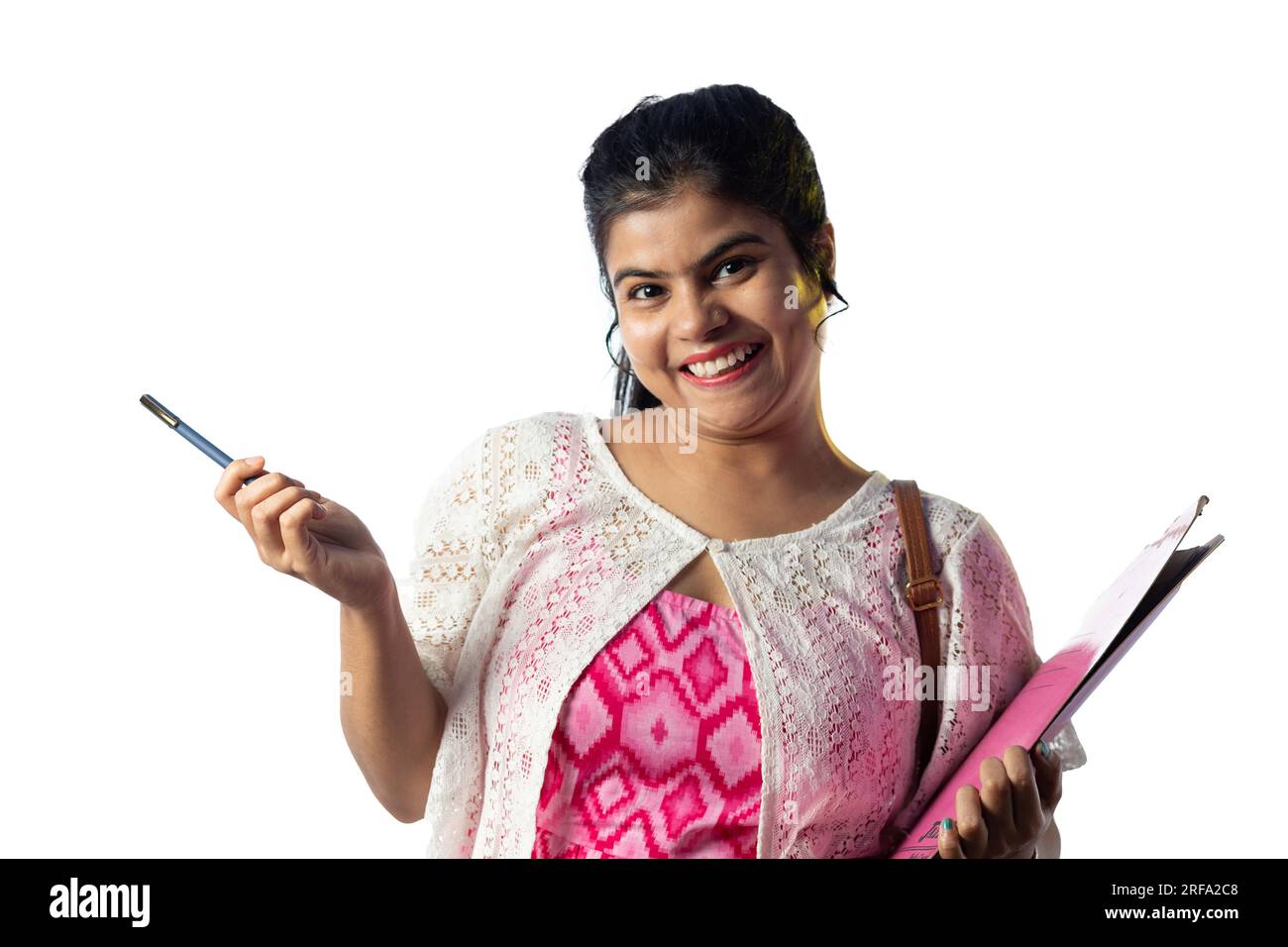 A pretty young Indian girl with books in hand pointing with smiling ...