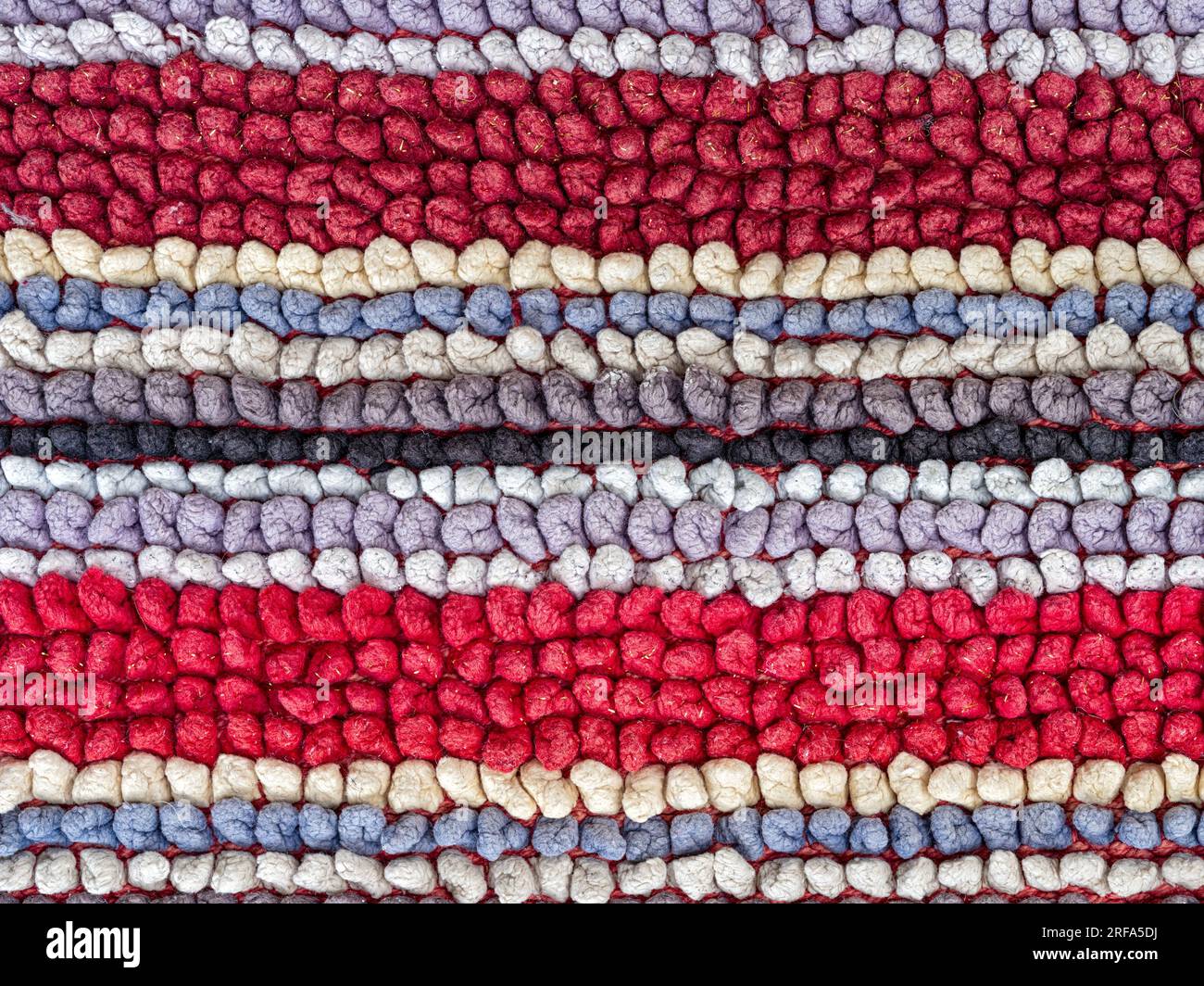The detail of the linear patterns in a colorful woven fabric rug Stock Photo
