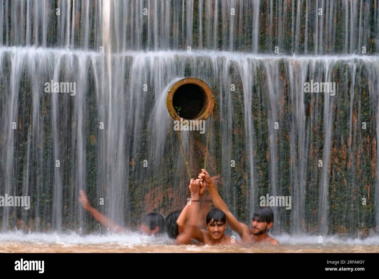 Young men cool themselves off in a waterfall as temperatures reached 36 C.  (96.8 F.) in Islamabad, Pakistan, Friday, July 14, 2023. (AP Photo/Anjum  Naveed Stock Photo - Alamy