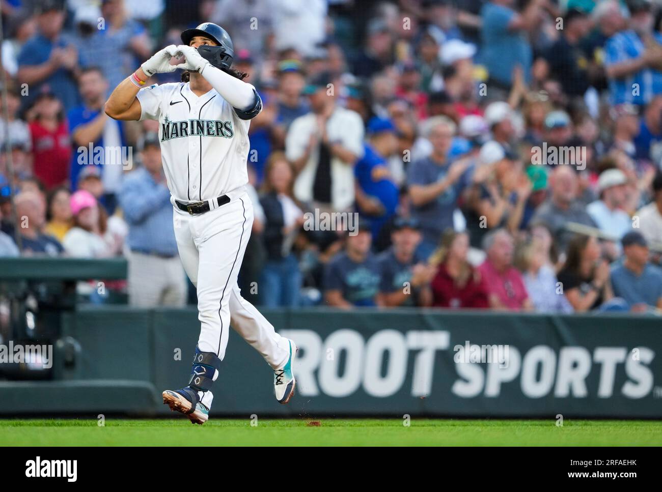Seattle Mariners' Eugenio Suarez makes a heart as he rounds the