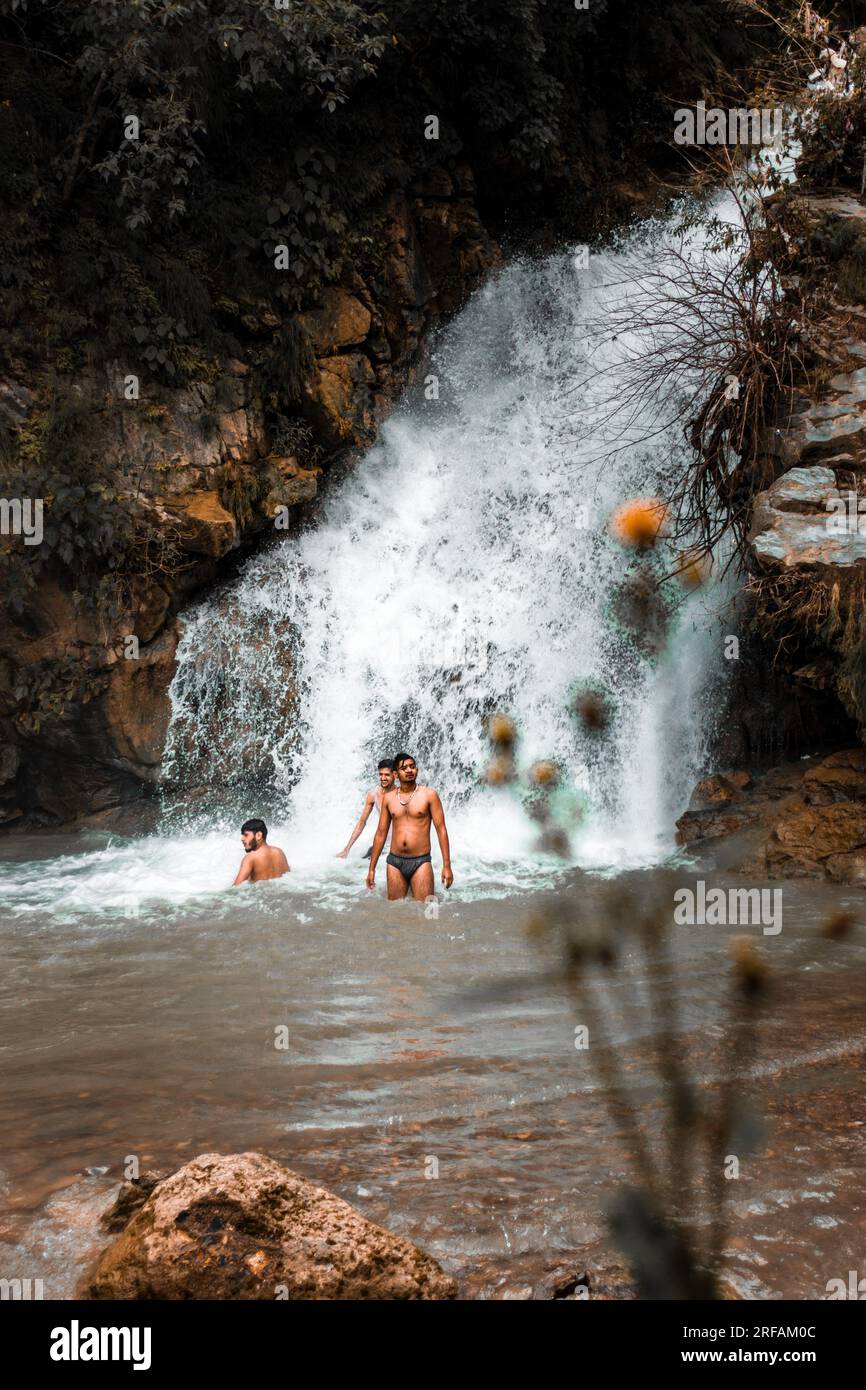 Oct.14th 2022 Uttarakhand, India. Young friends enjoying a refreshing waterfall bath on the outskirts of Dehradun City, Shikhar Fall Stock Photo