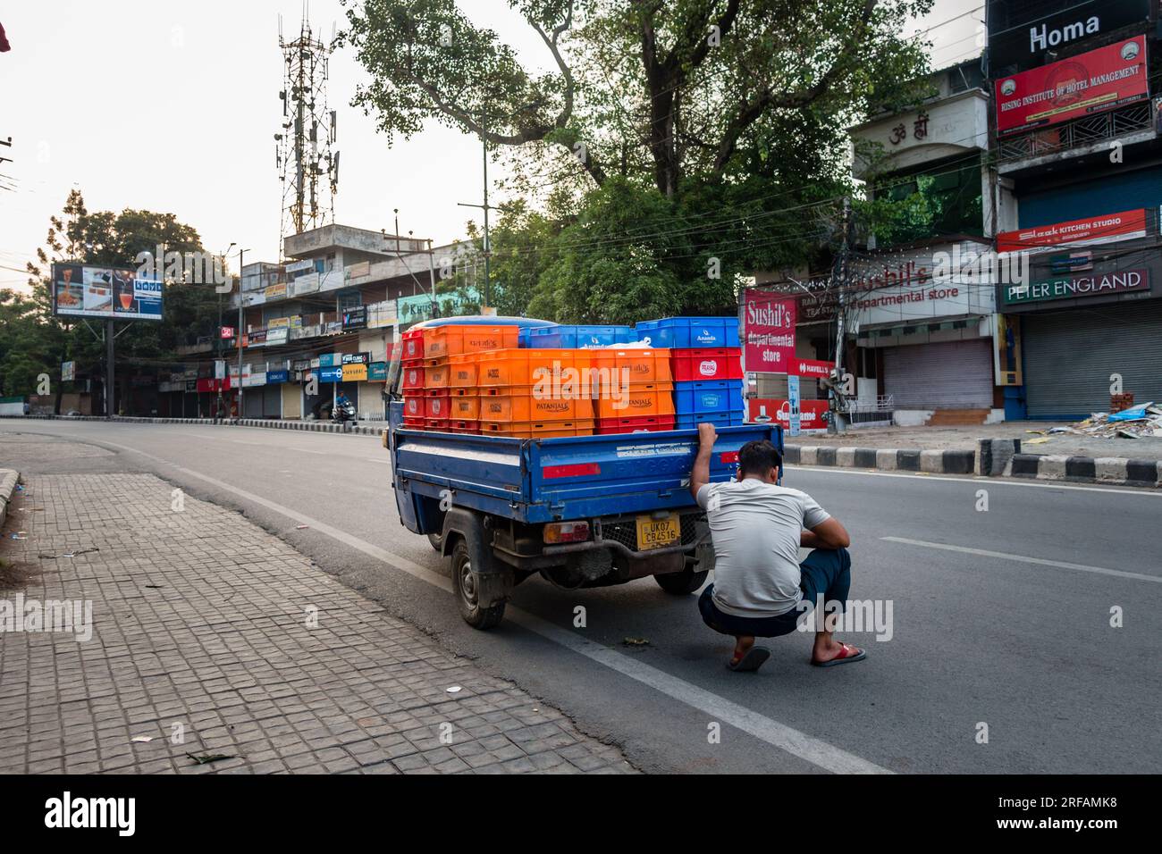 Oct.14th 2022 Uttarakhand, India. A 3-wheeler milk loader breaks down on the road as the driver inspects underneath. Capturing a rural transport misha Stock Photo