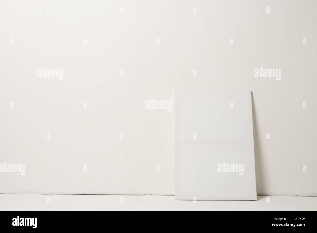 White canvas and copy space leaning against white wall background Stock Photo