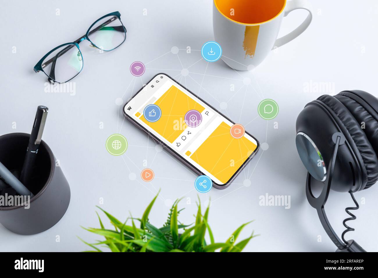 Phone on work desk with social network app and social media icons flying around with network nodes concept Stock Photo