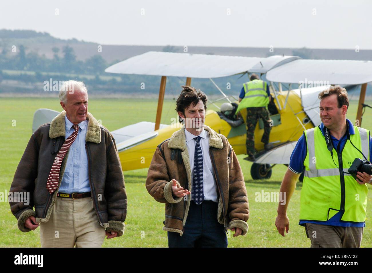 Actor Tom Ward at Duxford, Cambridgeshire, UK, walking back in after a flight in a Classic Wings Tiger Moth biplane. BBC Silent Witness TV star Stock Photo