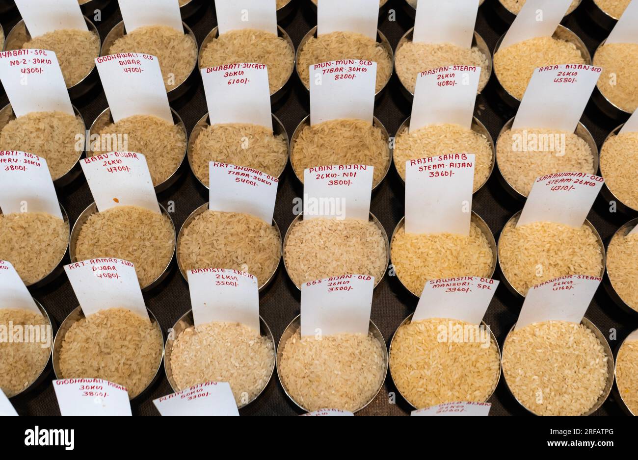 Rice trader displays variety of rice samples at a wholesale store, in Guwahati, Assam, India on August 2, 2023. Shortages of non-basmati rice caused by rains and drought in India, the Indian government ban exports of rice to ensure domestic supply. Credit: David Talukdar/Alamy Live News Stock Photo