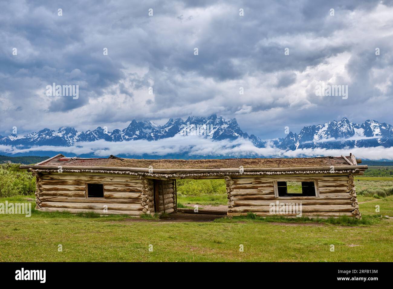 J.P. Cunningham Cabin, Cunningham Cabin Historic Site and Grand Teton Range under heavy clouds, Grand Teton National Park, Wyoming, United States of A Stock Photo