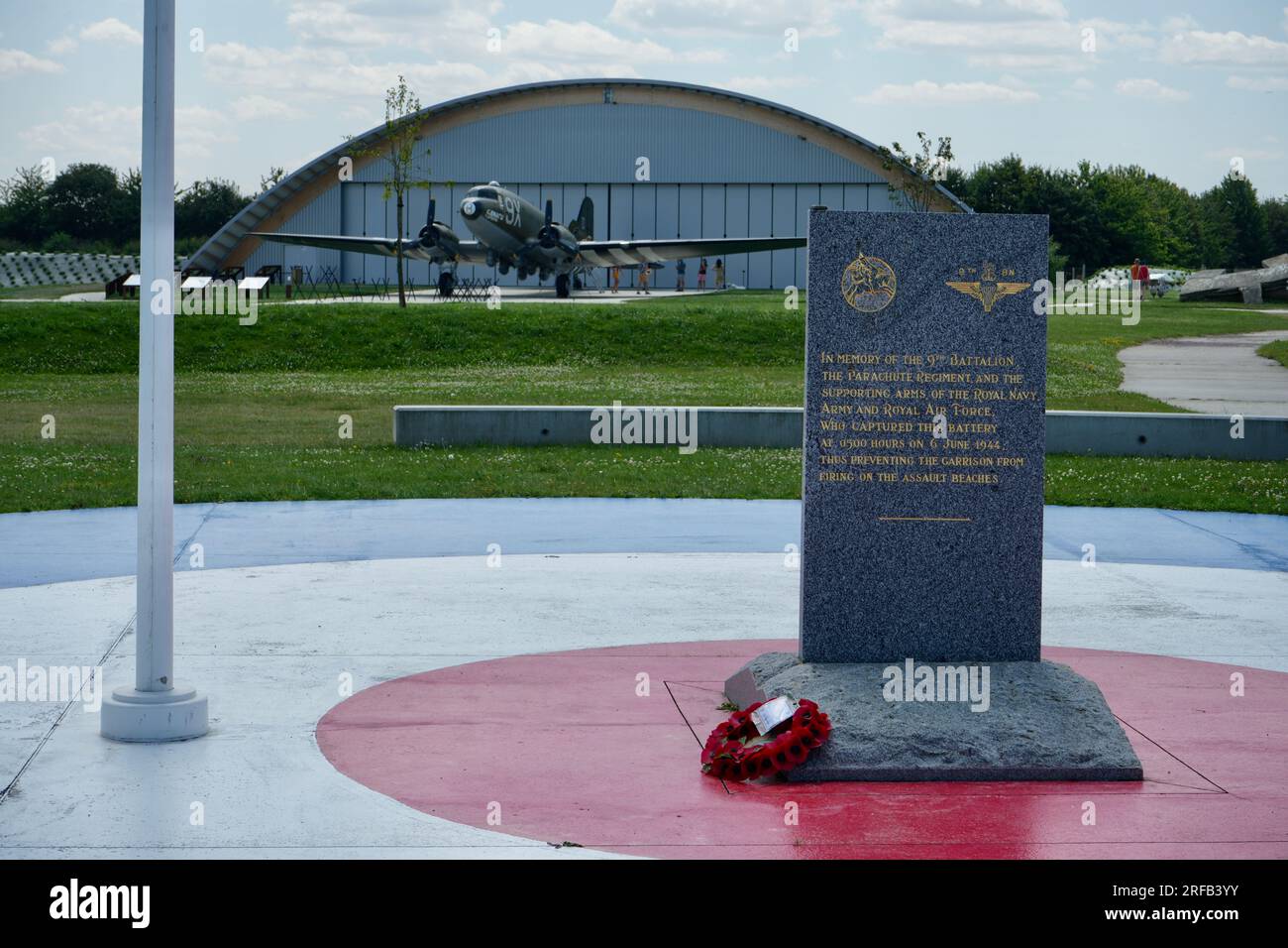 Memorial to the 9th Battalion Parachute Regiment at The Merville Gun Battery with Douglas C47 Dakota behind. Stock Photo