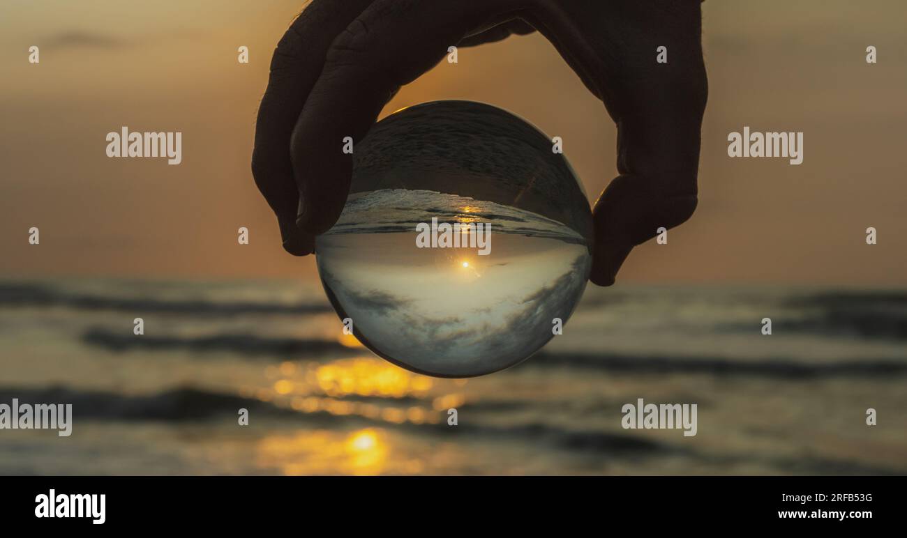 sunset on the beach seen with crystal ball Stock Photo - Alamy