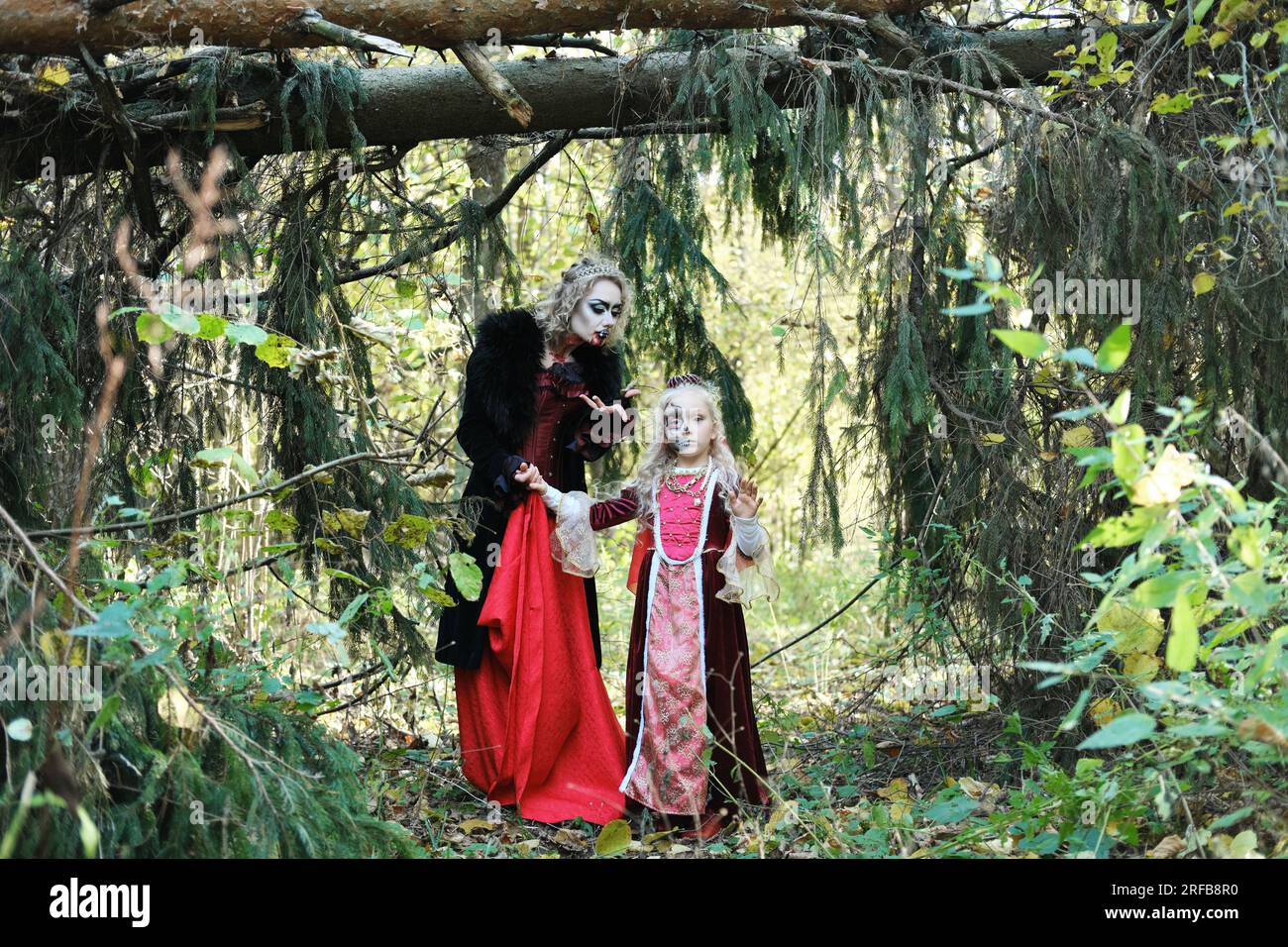 A woman in the form of a vampire or a sorceress poses in the forest with a  girl in fairy-tale makeup and medieval dress. Look for Halloween. Horizonta  Stock Photo - Alamy