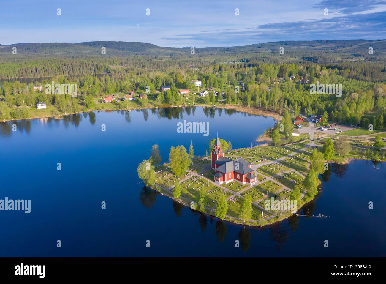 Aerial view over the red wooden Rämmens kyrka / church on promontory in lake Näsrämmen at Rämsnäs / Rämmen in summer, Värmland County, Sweden Stock Photo