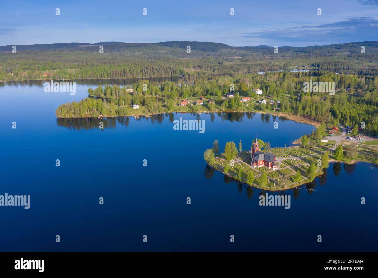 Aerial view over the red wooden Rämmens kyrka / church on promontory in lake Näsrämmen at Rämsnäs / Rämmen in summer, Värmland County, Sweden Stock Photo