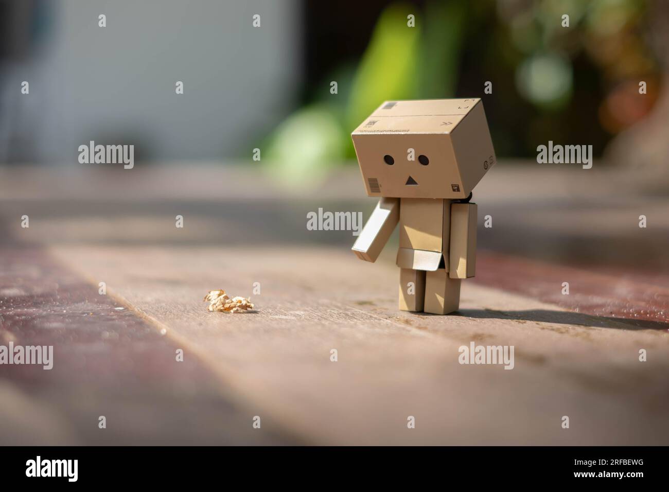 Small wooden toy robot danbo lonely isolated alone sad character, wood floor outdoor cartoon box anime happy art concept nature summer, brown doll cut Stock Photo
