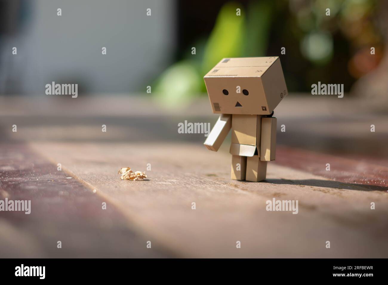 Small wooden toy robot danbo lonely isolated alone sad character, wood floor outdoor cartoon box anime happy art concept nature summer, brown doll cut Stock Photo