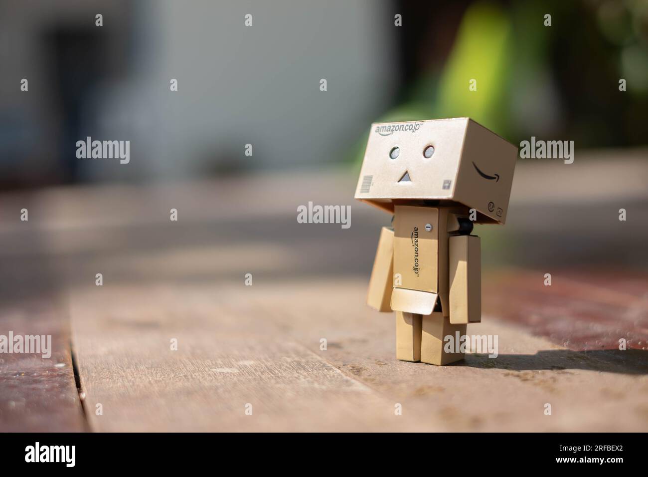 Small wooden toy robot danbo lonely isolated alone sad character, wood floor outdoor cartoon box anime happy art concept nature summer, brown doll cut Stock Photo