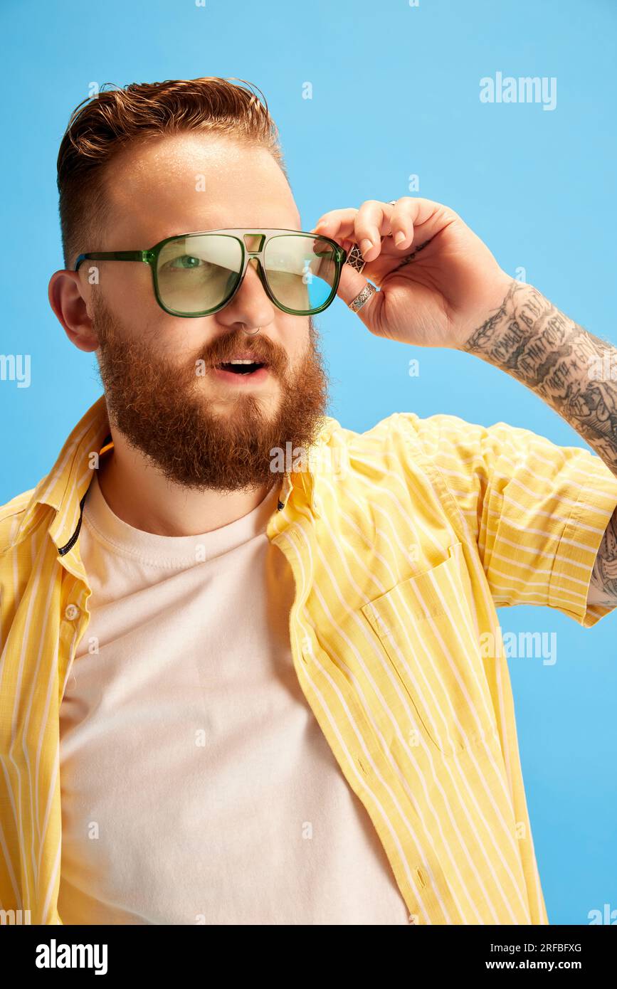 Portrait of bearded redhead man in sunglasses, wearing yellow shirt ...