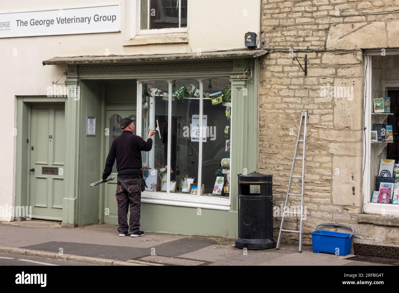 Window cleaner at work, Tetbury, Gloucestershire, UK Stock Photo