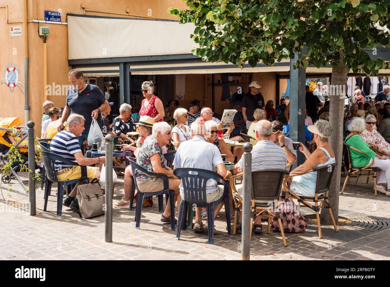 People in street cafe on market day, Marseillan, Herault, Occitanie, France Stock Photo