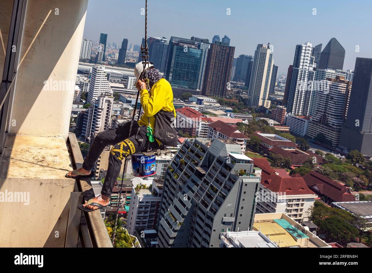 Thai maintenance worker abseiling outside high rise building, Sukhumvit ...