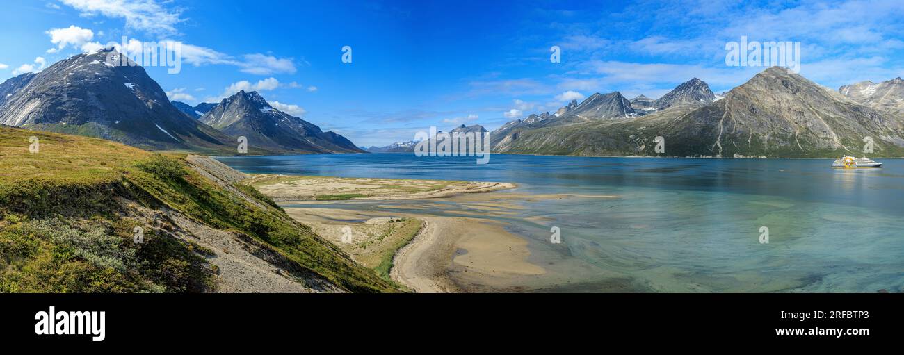 panoramic image of the steep sided rocky mountains on both sides of the tasermiut fjord greenland on a bright sunny day Stock Photo
